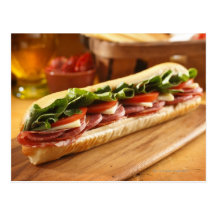 An Italian sub sandwich with 2 Post Cards