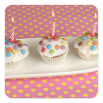 Birthday muffins with icing, sprinkles and square sticker