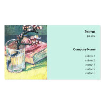 Blossoming almond branch in a glass with a book business cards
