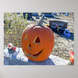 Carved pumpkin on grave stone poster