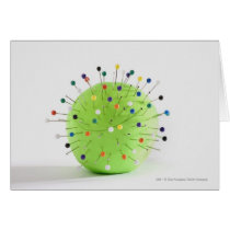 Close-up of straight pins inserted into a ball cards