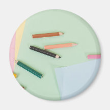 Colour pencils and paper on children desk refrigerator magnet