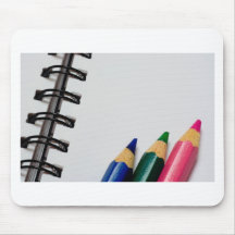 Colour pencils on a notepad mouse pads