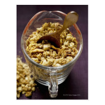 Crunchy muesli with wooden spoon in a measuring postcards