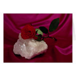 Crystal and rose kept on red background card