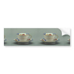 Cup and saucer with colorful flower designs on it. bumper sticker