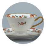 Cup and saucer with colourful flowers on it. round stickers