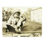 Cute girl in a peddle car postcard