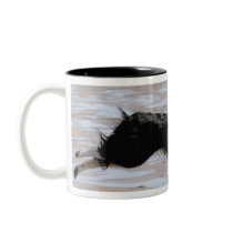 Dog chasing a ball at the beach mugs