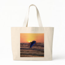 Dolphin at sunset canvas bags