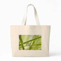 Earth in a drop tote bags