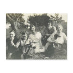 Family and dog sitting on grass post card
