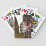 female hand holding four string bass neck playing cards