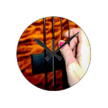 female hand pulling bass string 1 posterized wall clocks