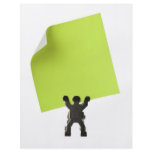 Figurine holding a piece of blank yellow paper flyers