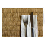 Fork and knife on a dried grass mat card