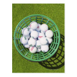 Golf balls in a basket sitting on short green post cards