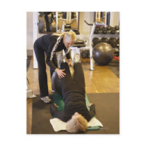 Instructor helps senior client with stretches post card