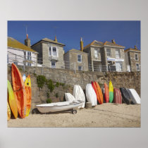 Kayaks and dinghies stacked against seawall at