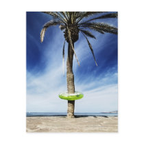 Large palm tree on a sandy beach with inflatable post cards