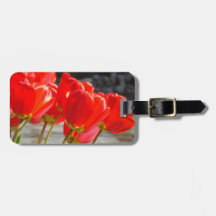 Le bagage étiquette les fleurs rouges faites sur c étiquette à bagage