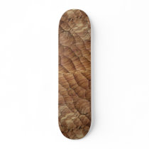 Lines carved in pale brown wood skate board deck
