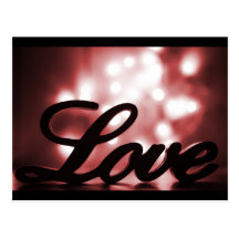 Love sign with red sparkle lights behind postcards