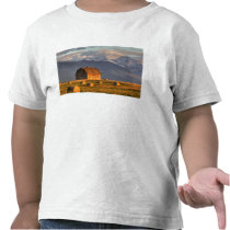 Old barn framed by hay bales and dramatic t-shirt