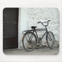 old bike leaning on white wall mousepad