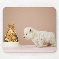 Puppy looking at pile of biscuits in dog bowl mouse pad