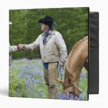 Ranchers shaking hands across the fencing in vinyl binder