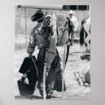 Rear view of cowboy hauling gear posters