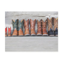 Row of cowboy boot on porch of log cabin postcard