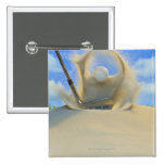 sand wedge hitting a golf ball out of a sand 2 pinback buttons
