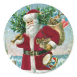 Santa in the Snow Carrying Drum and Tree Round Stickers