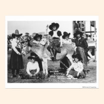 Seven rodeo cowgirls jokingly posing with a donkey posters