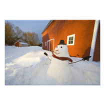Snowman in front of red barn in Columbia Falls