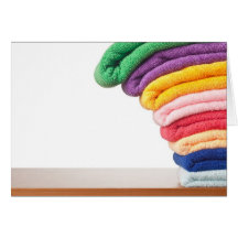 Stack of colourful microfiber towels toppling greeting card