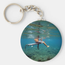 Surfer sitting on surfboard over coral reef key chain