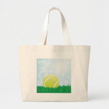 tennis ball on grass tote bags