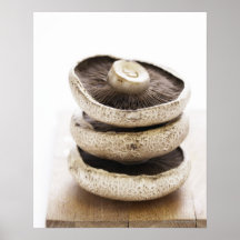 Three flat mushrooms in pile on wooden board, print
