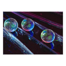 Three glass marbles rolling on smooth surface invite