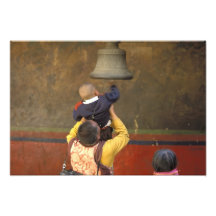 Tibetan Buddhist monk lifting a boy to ring a Art Photo