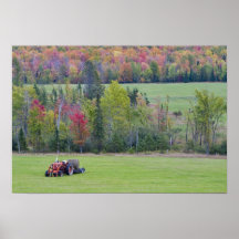 Tractor with hay bale in green field with poster