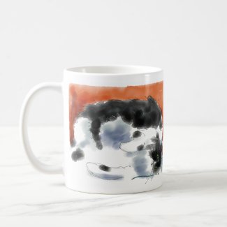 Tuxedo cat curled up with paws coffee mugs