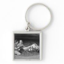 Two couples on beach sitting around campfire keychain