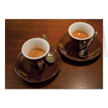 two cups of freshly brewed espresso coffee on a card