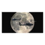 two helicopters silhouetted by a full moon