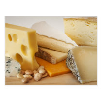 Various cheeses on chopping board postcards