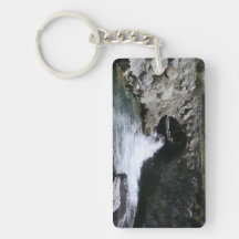 Water flowing under a mountain bridge keychain